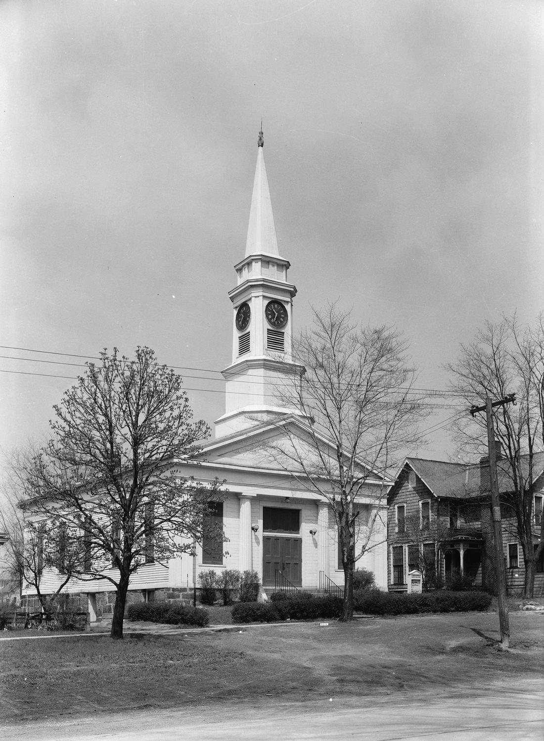 A 1930s black and white photograph of a white church with tall columns and a steeple, the Twinsburg Congregational Church on Public Square